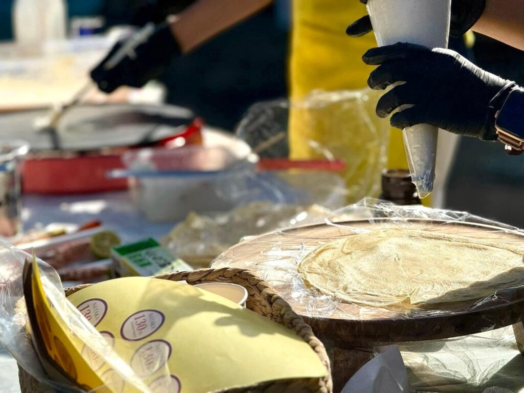 クレープにトッピングをしているスタッフの手元写真